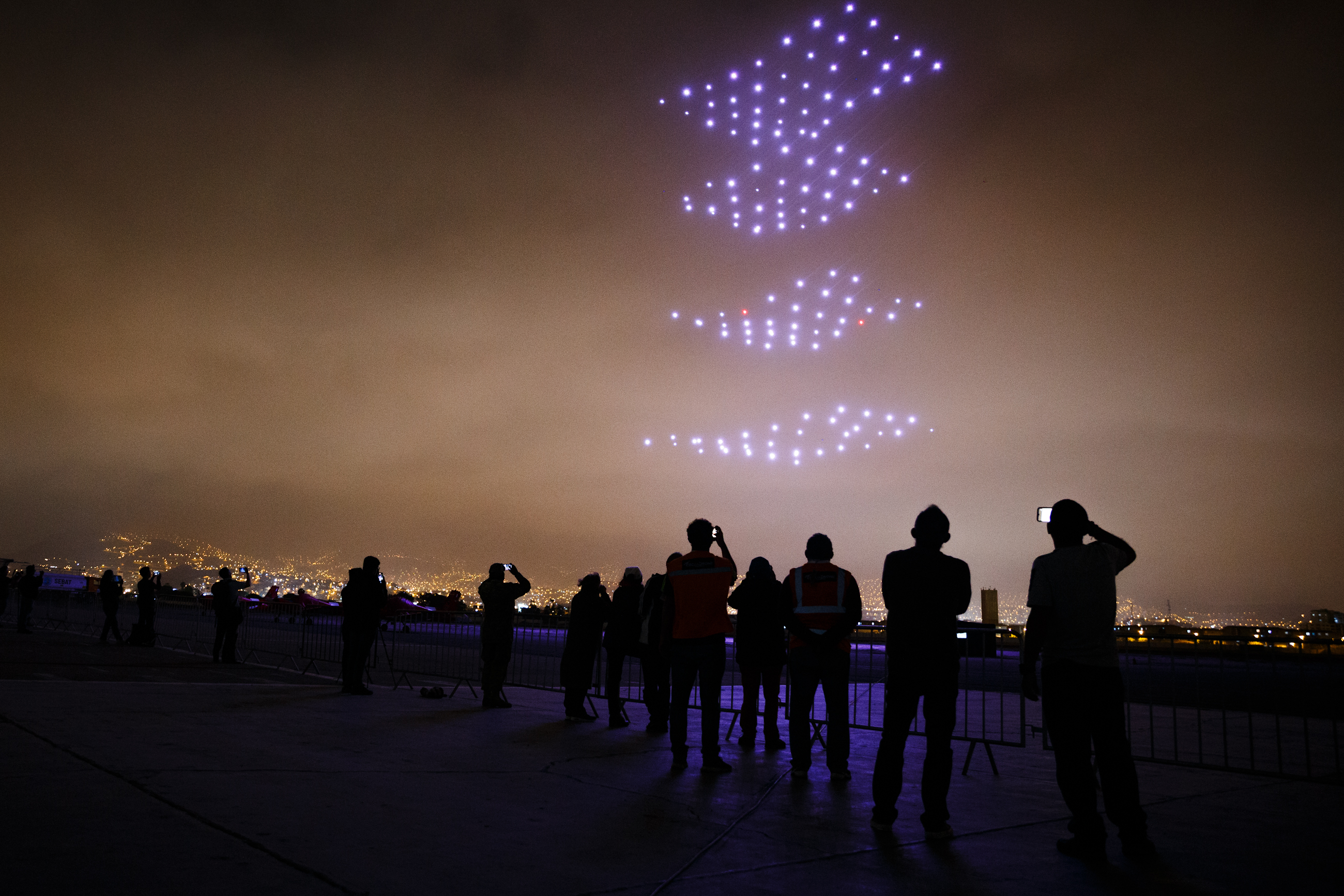 Espectáculo nocturno de drones formando una esfera brillante en el cielo